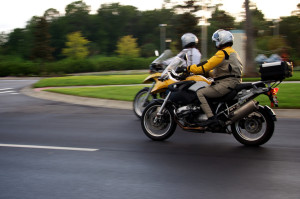 Photo of motorcyclists riding down street