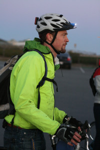 Cyclist wears bright green jacket and lights on helmet